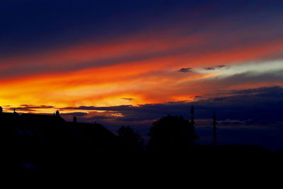 Silhouette trees against scenic sky