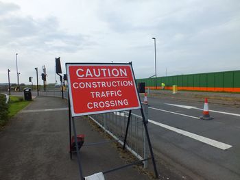 Road sign against sky