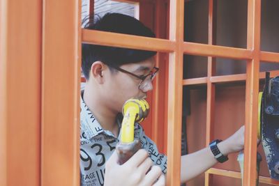 Young man standing in telephone booth