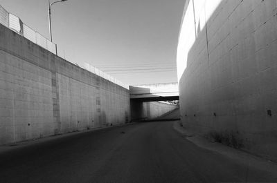 Empty road amidst buildings against clear sky