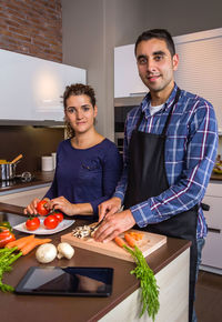Portrait of young man standing in kitchen at home