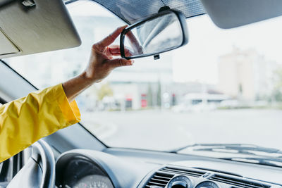 Woman's hand adjusting car mirror