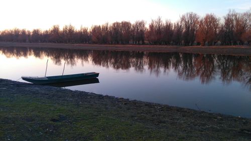 Boat moored at lakeshore against sky