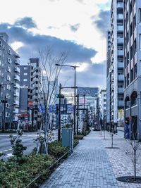 Buildings in city against cloudy sky