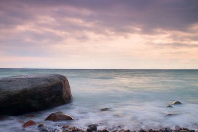 Romantic atmosphere in peaceful morning at sea. big boulders in smooth wavy sea. style toned effect