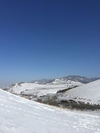 Snowcapped mountains against clear blue sky