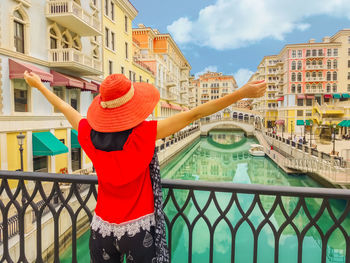 Woman standing by railing against buildings in city