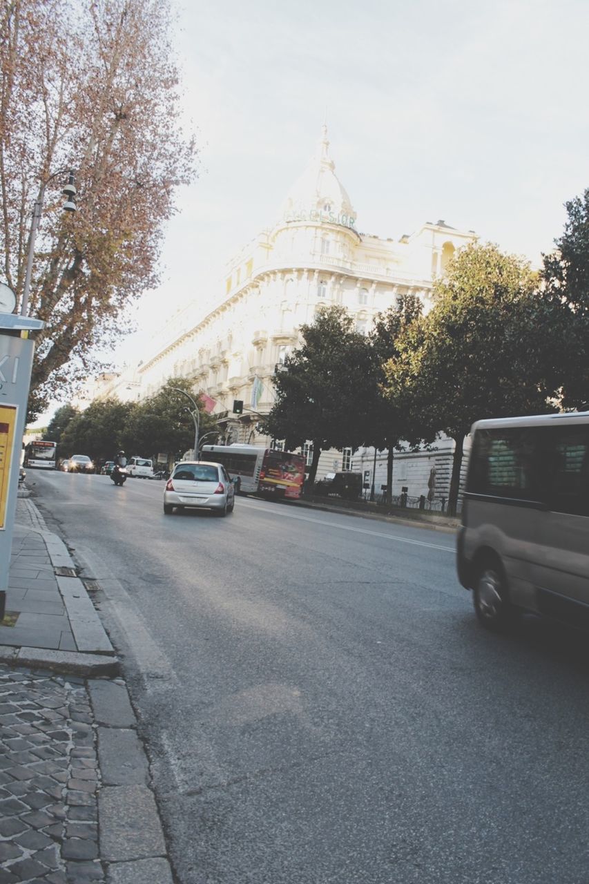 transportation, car, land vehicle, architecture, mode of transport, tree, built structure, road, street, building exterior, city, traffic, travel, sky, road marking, the way forward, travel destinations, on the move, clear sky, connection