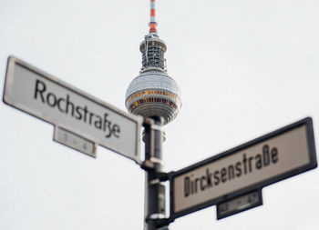 Low angle view of sign on building against sky