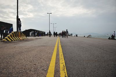 Group of people on road against sky