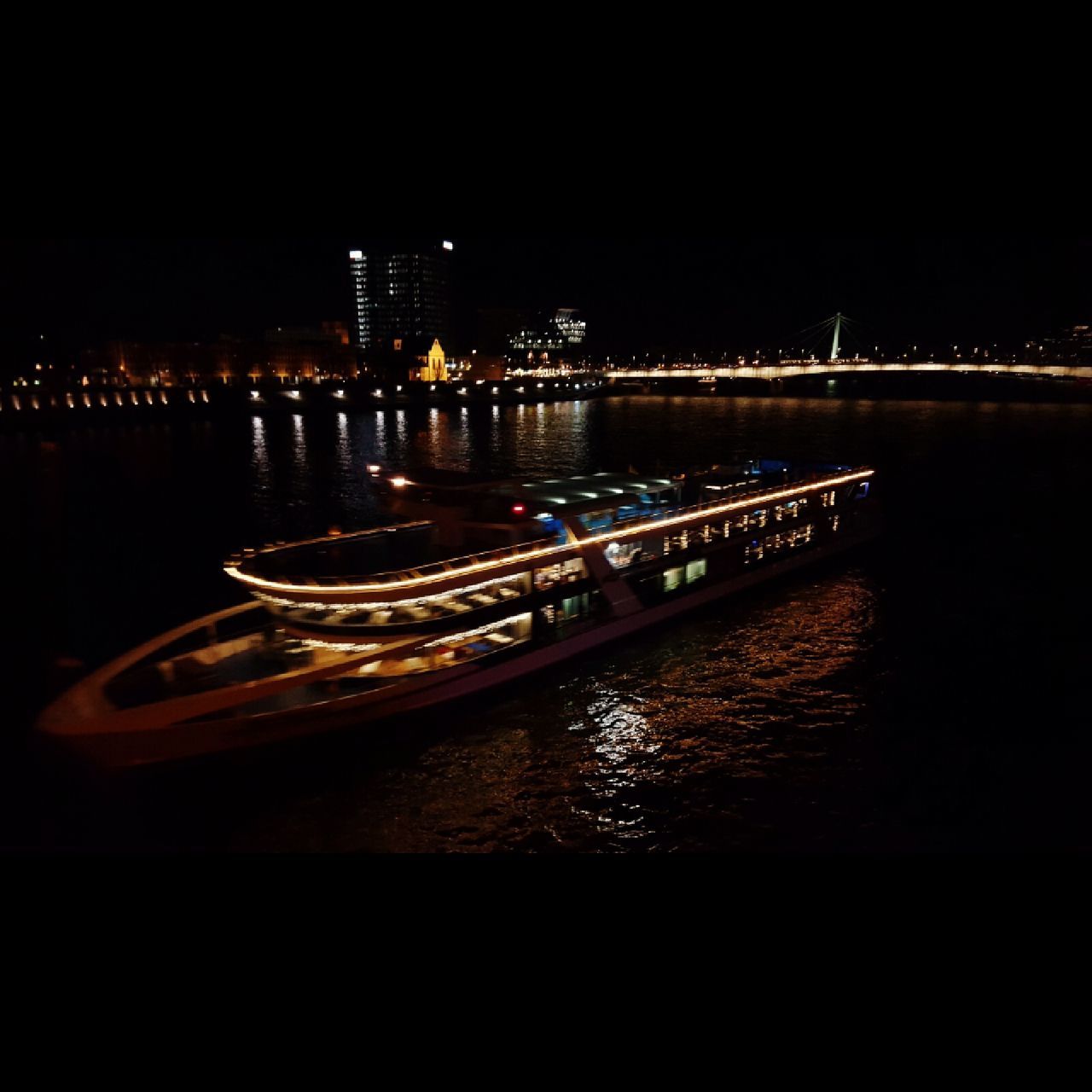 architecture, built structure, water, illuminated, city, river, night, building exterior, bridge - man made structure, transportation, connection, waterfront, cityscape, nautical vessel, engineering, bridge, reflection, boat, city life, mode of transport