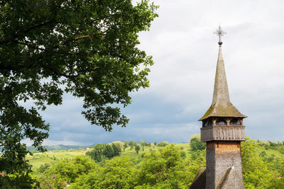 Low angle view of trees and building against sky