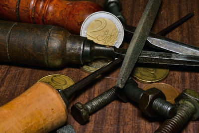 Close-up of coins and work tools on table