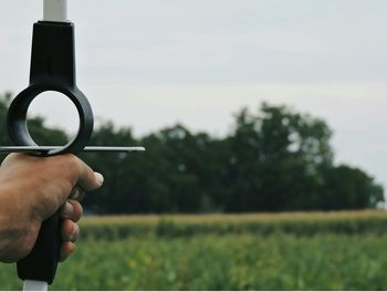 Close-up of cropped hand holding grass