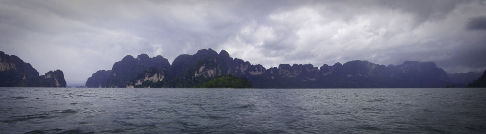 Panoramic view of sea and mountains against sky