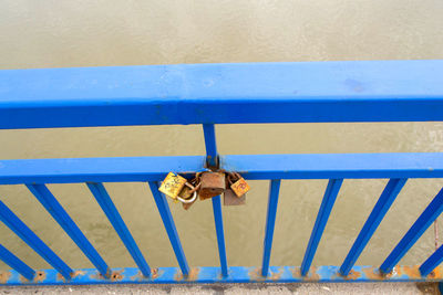 Close-up of padlocks on railing against wall