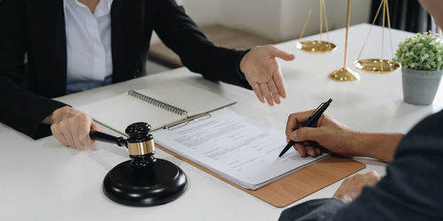 Midsection of lawyer working at table