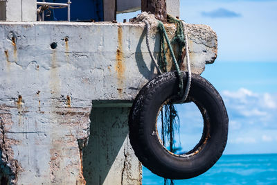 Close-up of rusty ship on sea against sky