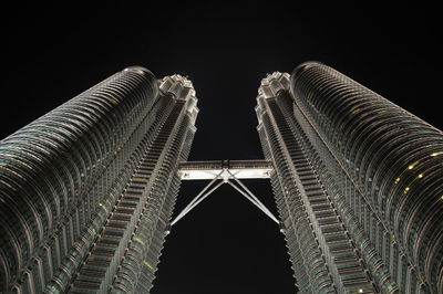 Low angle view of twin towers petronas kuala lumpur against sky at night