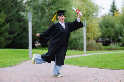 Rear view of woman holding mortarboard