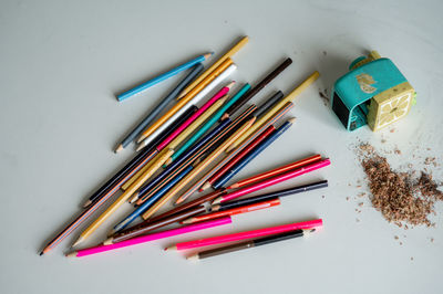 High angle view of colored pencils on white background