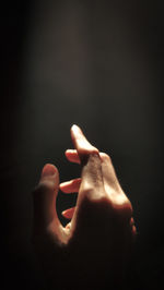 Close-up of hand against black background