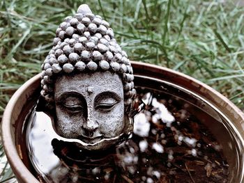 Close-up of buddha statue in water