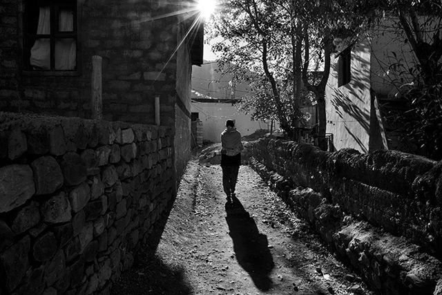 building exterior, architecture, built structure, lifestyles, sunlight, full length, walking, rear view, men, leisure activity, tree, shadow, street, person, casual clothing, standing, city, building