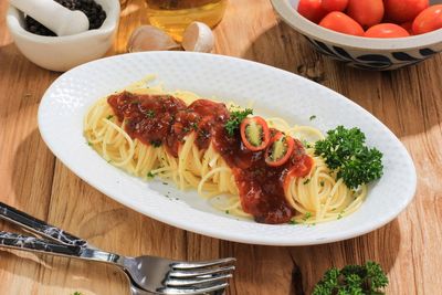 Delicious spaghetti served on white oval plate