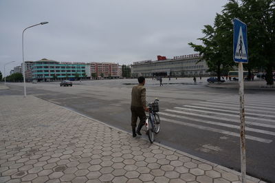 Full length of people walking on footpath in city