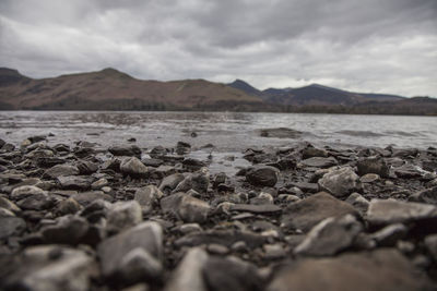 Surface level of rocks on shore against sky