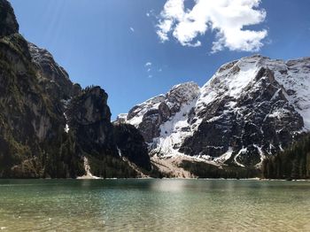 Scenic view of lake by snowcapped mountains against sky