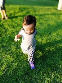 High angle view of happy child running on grassy field at park