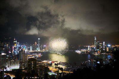 Firework display at victoria harbour in city during night