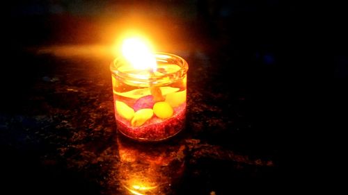 Close-up of lit candle in dark room