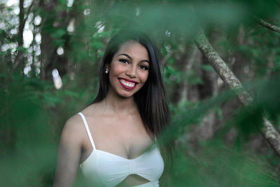 Portrait of smiling young woman in forest