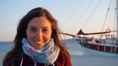 Portrait of smiling young woman against sky