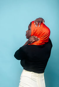 Woman looking away in front of blue background