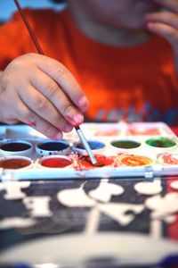 Midsection of boy holding paintbrush over palette