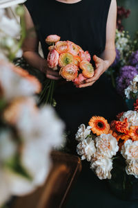 Midsection of person holding rose bouquet