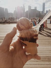 Close-up of hand holding ice cream cone in city