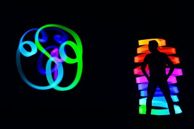 Low angle view of illuminated lighting equipment against black background