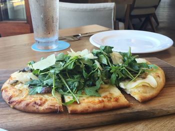 Pizza with vegetables on cutting board