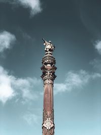 Low angle view of statue of column against sky