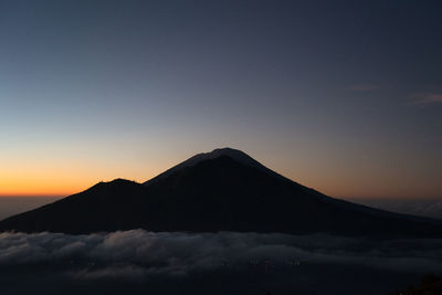 Scenic view of volcanic mountain against sky during sunset