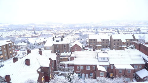 High angle view of snow covered houses against sky