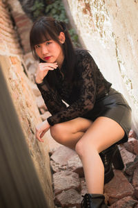 Portrait of beautiful young woman leaning outdoors