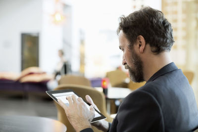 Businessman using digital tablet in hotel restaurant