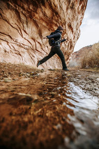 Man surfing on rock in water