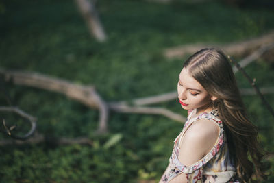 High angle view of beautiful young woman sitting in park